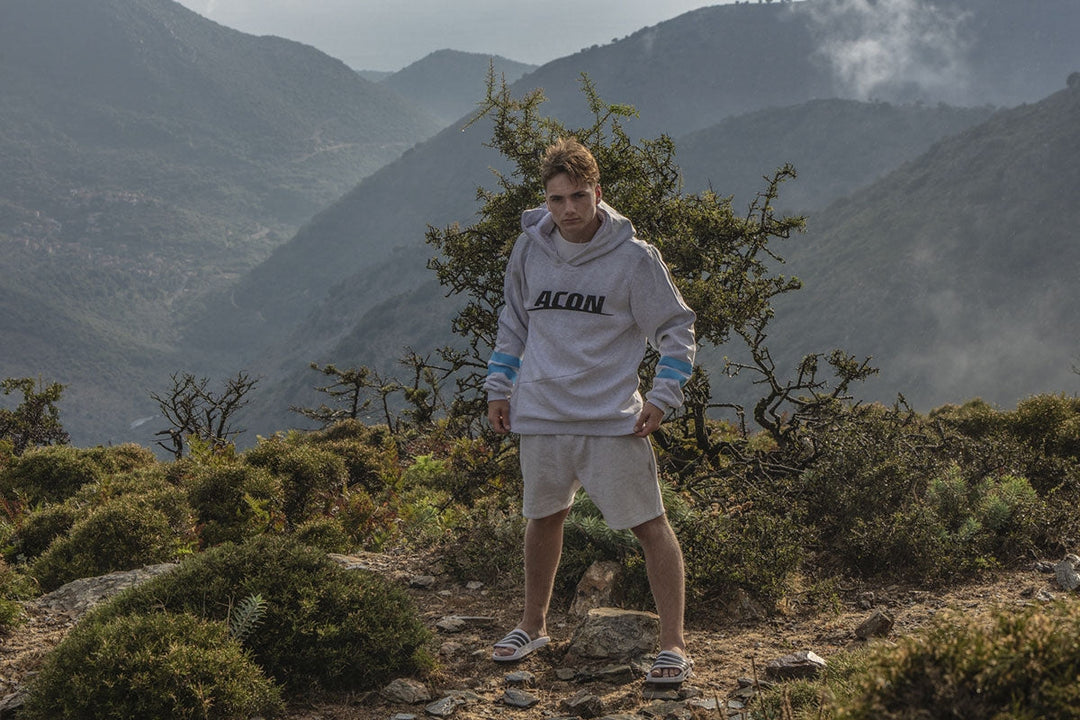 En man med ACON Hoodie i en skogsutsikt