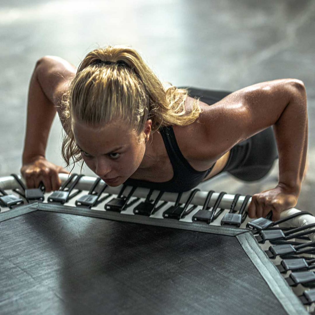 Kvinna tränar på Acon FIT 1,41 m vit Hexagon-trampolin.