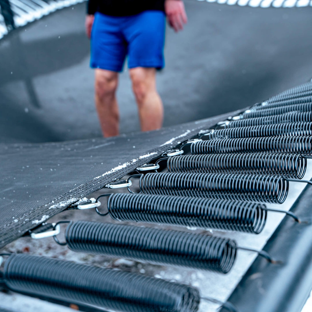 Trampolinhopparens fötter på mattan, performancefjädrar.
