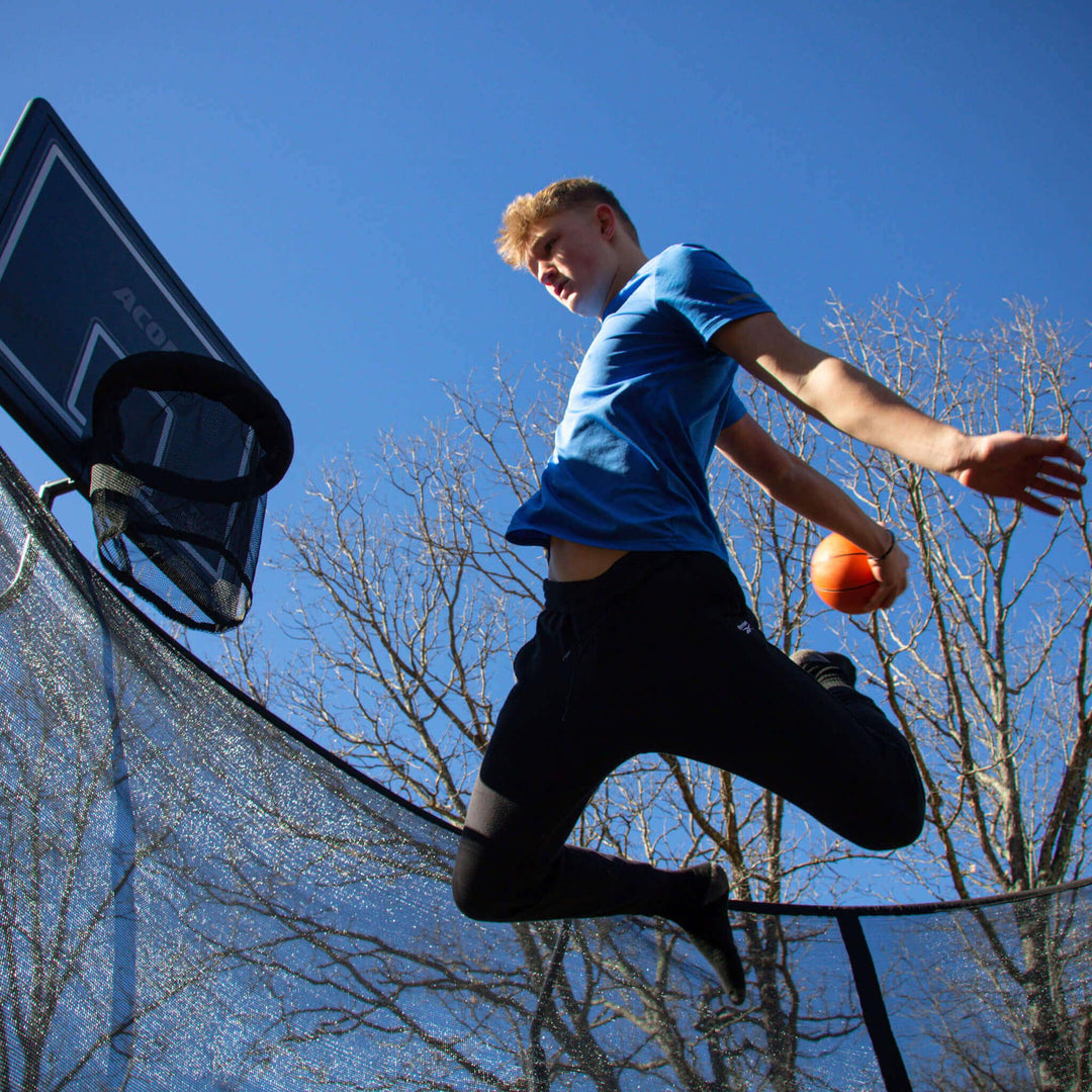 Basketspelare på en rund studsmatta.